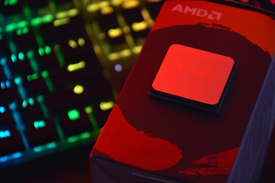 A close-up of an AMD Ryzen 7 5800X processor in a packaging box with backlit keyboards in the background.