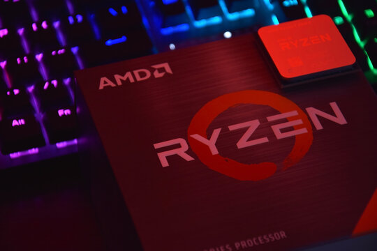 A close-up of an AMD Ryzen 7 5800X processor in a packaging box with backlit keyboards in the background.