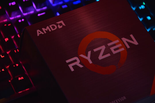 A close-up of an AMD Ryzen 7 5800X processor in a packaging box with backlit keyboards in the background.