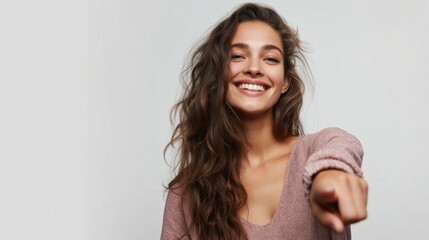Naklejka premium Personal empowerment and positive affirmation A smiling woman points her finger directly at the camera with a confident expression embodying self-esteem and motivation in a studio setting.