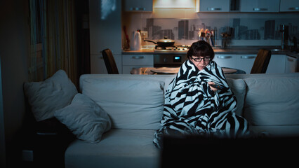 Woman Watching TV at Night Wrapped in Blanket on Couch, have fun and enjoy