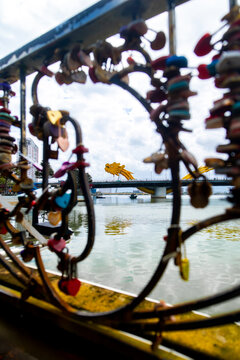 View of a bridge adorned with love locks, a cascade of colorful metal against the tranquil waters, symbolizing enduring affection, Da Nang, Da Nang, Vietnam.
