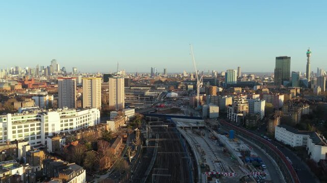 London Borough of Camden featuring the new HS2 Euston railway station and urban sprawl, with city of London and BT Tower on the horizon at golden hour