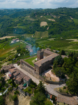 Aerial view of the ancient fortress with its weathered stone walls and verdant courtyard amidst rolling hills, Sorrivoli, Emilia Romagna, Italia.