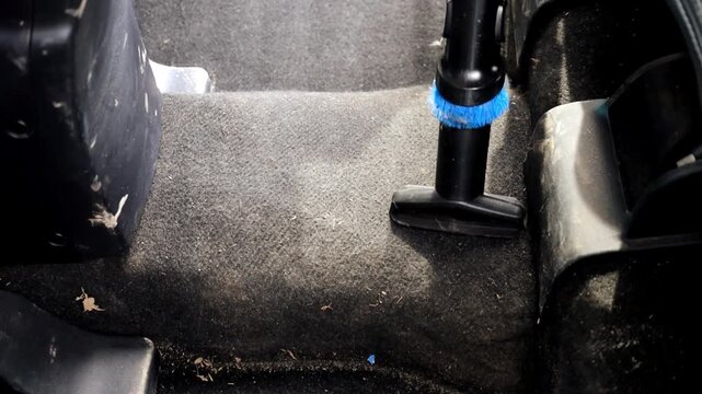 Professional deep cleaning of a heavily soiled car seat using a powerful vacuum cleaner. Removing dust, crumbs, and stubborn stains from the textile upholstery.
