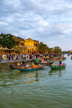 Hoi An, Vietnam - 28 January 2026: View of the lantern-lit Hoi An bridge reflecting on the tranquil waters, as boats float by under a twilight sky.