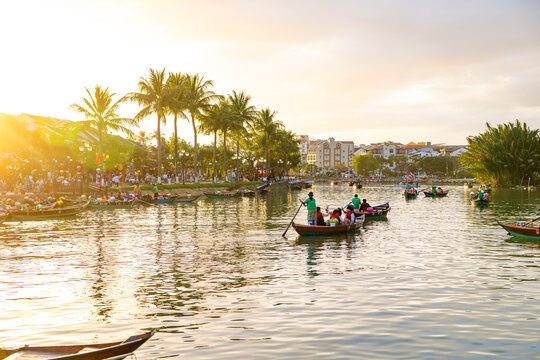 Hoi An, Vietnam - 28 January 2026: View of the river reflecting the golden sunset, with boats gliding under the lantern-lit bridge, capturing the essence of Old Town.