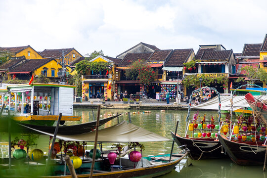 Hoi An, Vietnam - 28 January 2026: View of boats floating on the river, vibrant buildings lining the waterfront, showcasing the vivid colors of Hoi An Lantern Bridge.