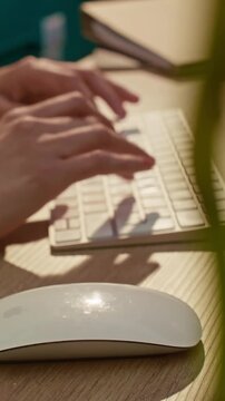 Sleman, ID - March 24, 2026: vertical video close up hands working using apple magic mouse and keyboard