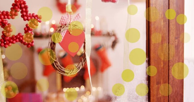 Animation of yellow dots moving over window with christmas decoration
