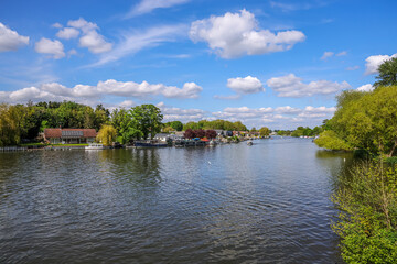 Obraz premium View of riverbank of River Thames on a clear spring day, Walton-on-Thames, England, UK. Walton-on-Thames, known locally as Walton, is a market town on the south bank of the Thames in northwest Surrey,
