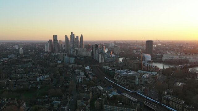 London skyline showing Vauxhall, the River Thames, and Nine Elms towers with trains running on railways during a serene sunrise, capturing essence of the city