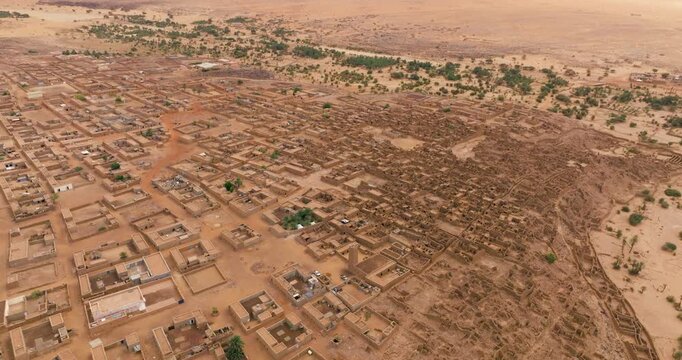 Aerial View Of Desert Town Of Ouadane In Mauritania, With Sand-colored Buildings And Dusty Streets. tilt-up shot