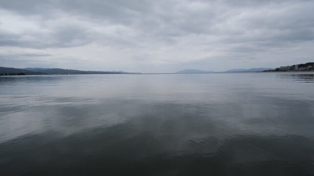 Calm Lake Surface with Gentle Ripples and Distant Horizon