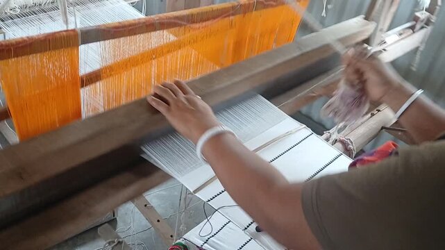 Handloom weaver in India working in her loom.	