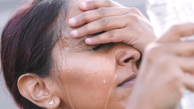 Woman, fitness and rest with water on break, splash and thinking of body goal post workout or relief. Outdoor, runner and Indian person with liquid for hydration, calm and cool down after exercise