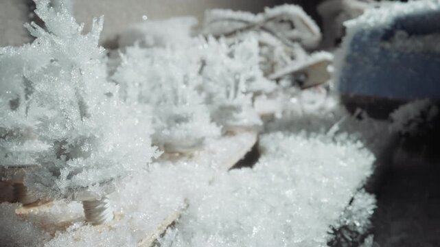 Wide frost covering abandoned gear, worn straps and fabric crusted with ice crystals, muted blue object in frame, cold light, desolate street atmosphere, implied evacuation after nuclear winter