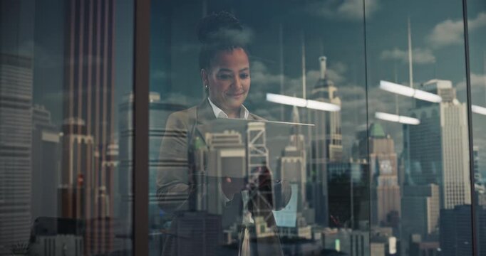 Confident Black Businesswoman With Laptop Stands by a High-rise Window, Studying the City&rsquo;s Financial Skyscrapers and Growth Ahead, Then Reviewing Data With a Startup Leader&rsquo;s Focus on Success.