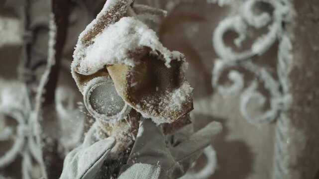 Gloved hands inspect frostcoated respirator up close against ornate ironwork, careful testing of filter and lens in cold degraded landscape, clinical tension and field laboratory vibe, residue