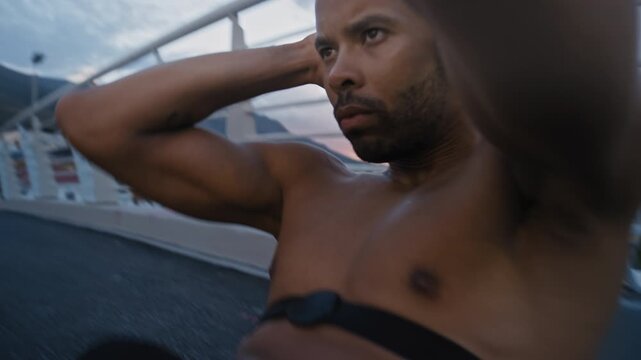 Black man, sit ups and fitness on ground in city for training outdoor, heart rate strap or iot on bridge. African person, exercise and shirtless with wearable tech, monitor or workout for abs in town