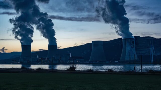 Timelapse of Cruas nuclear power plant at sunset, steam rising from cooling towers in dramatic evening light, France