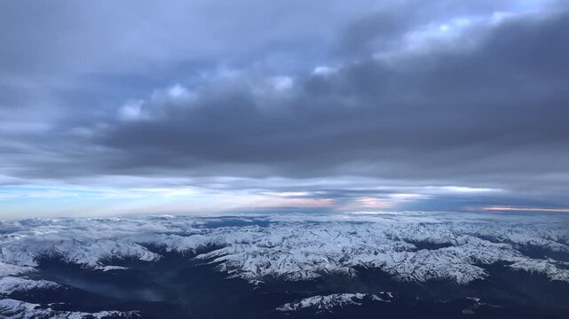 An elevated perspective of The Pyrees mountains coverd by snow under a layer of clouds at sunset. Hyperlapse accelerated x5.