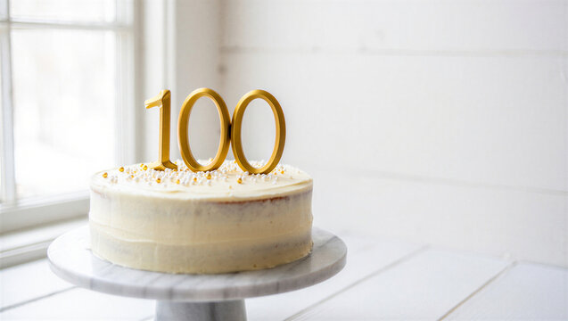 Minimalist birthday cake with gold number 100 topper celebrating a centennial milestone anniversary.
