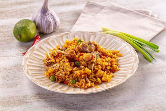 Savory fried rice with meat and vegetables served on a plate with fresh ingredients