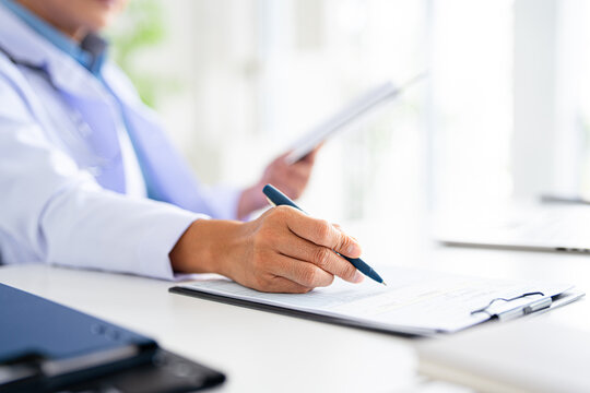 closeup Hand Writing, book and notebook by doctor or healthcare professional with a prescription or making notes in an office.