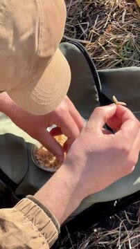 fisherman close-up baiting hook with maggots for fishing