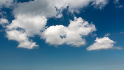 Obraz premium white, cottony clouds covering the clear blue sky