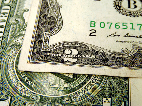 A close-up of a 2 and 1 dollar bill