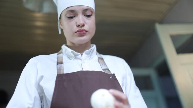 A female chef cooks in the kitchen at home wearing a chef's costume