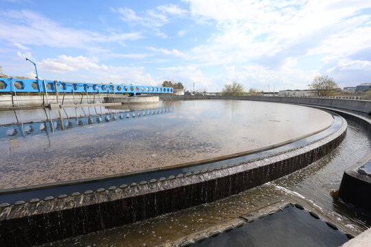 Sludge Settlement Stage: Secondary Sedimentation Basin at a Sewage Treatment Facility. Treated Effluent Overflowing from a Secondary Sedimentation Basin at a Sewage Facility