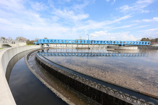Sludge Settlement Stage: Secondary Sedimentation Basin at a Sewage Treatment Facility. Treated Effluent Overflowing from a Secondary Sedimentation Basin at a Sewage Facility