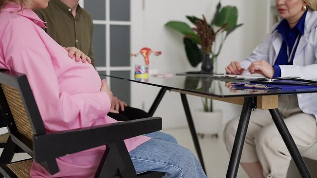 Expecting parents learning about possible genetic predispositions from OB doctor