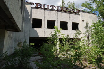 Fototapeta premium Abandoned Soviet Restaurant Building Overgrown with Trees in Pripyat