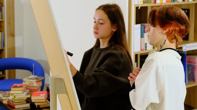 Students actively work together on seminar task and record structured notes on whiteboard. Women do collaborative seminar assignment