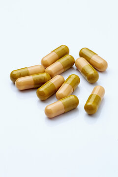 Macro close-up of multiple anthelmintic gelatin capsules scattered on white surface, pharmaceutical deworming medication concept