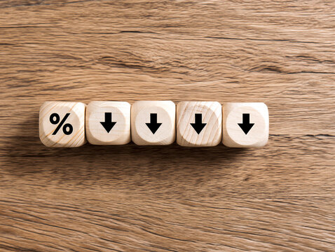 Wooden blocks showing percentage and downward arrows on table