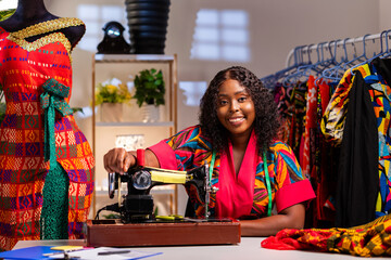 African female tailor creating unique garments in her workspace © Roger