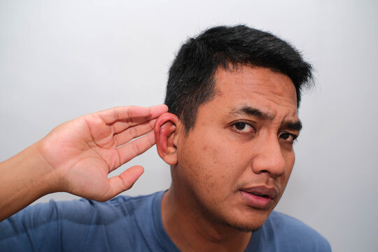 A close-up shot captures a person's ear with a red, swollen area, possibly indicating a skin irritation or infection, as fingers gently touch the lobe.
