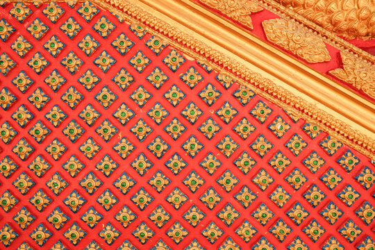 Traditional Thai Pattern Background with Golden Ornaments on Red Wall.