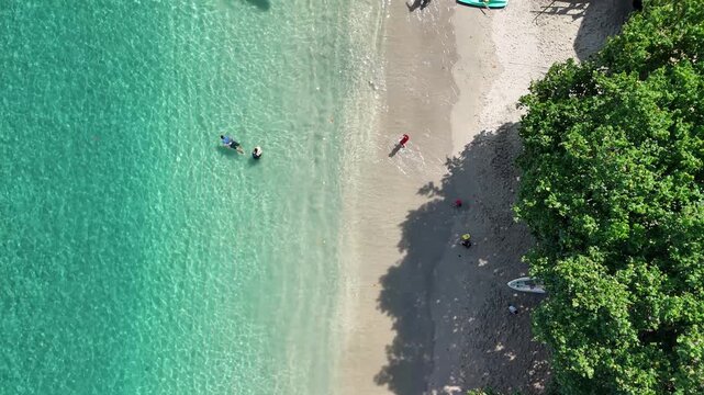 Aerial Bird's Eye View of Tourists Enjoying Clear Kayak and Swimming in Crystal Waters of Nipah Beach Lombok Indonesia