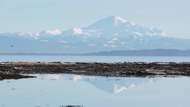 Mt Baker and reflection across Boundary Bay 4K UHD. Mt Baker reflection along the shore of Centennial Beach in Delta, British Columbia, Canada. 4K UHD.
