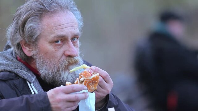 City Life Rhythms - Senior Man eating fast food  on Busy Street