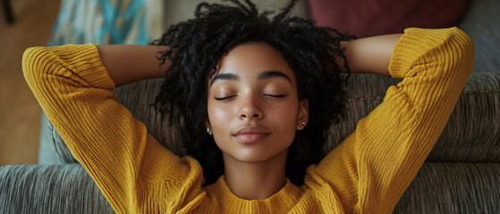 A girl in a yellow jumper is relaxing on the sofa, conveying a sense of calm and relaxation, making her the perfect choice for advertising home textiles 
