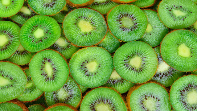 Top view of heap of sliced kiwi as textured background.