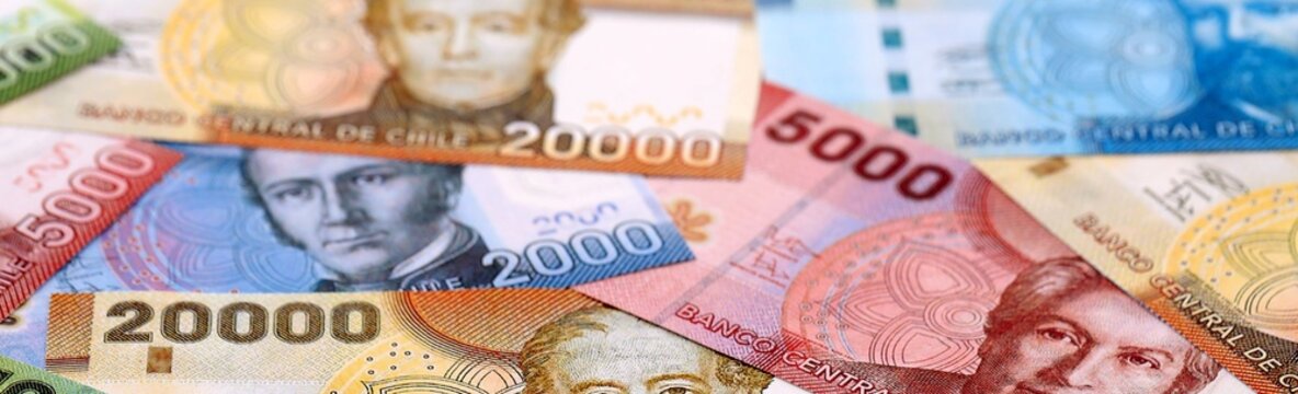 Chilean peso money bills pile on table. Chile banknotes of CLP currency close up.