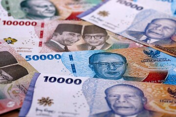 Indonesian rupiah money bills pile on table. Indonesia banknotes of IDR currency close up. © Larysa